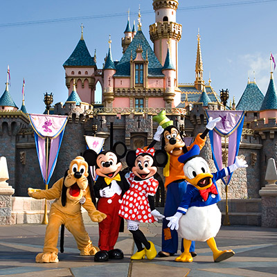 A group of Disney characters in front of the Disneyland castle