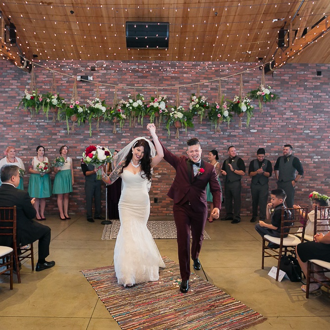 A couple raise their hands together in celebration of their marriage