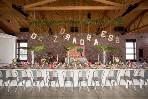 The Colony House Great Room prepped with a long dining table with floral decorations and hanging letter decorations