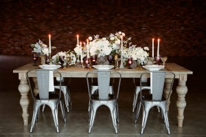 A beautifully decorated wooden table with white flowers and lit candles